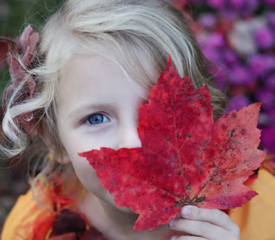 girl holding leaf to her face